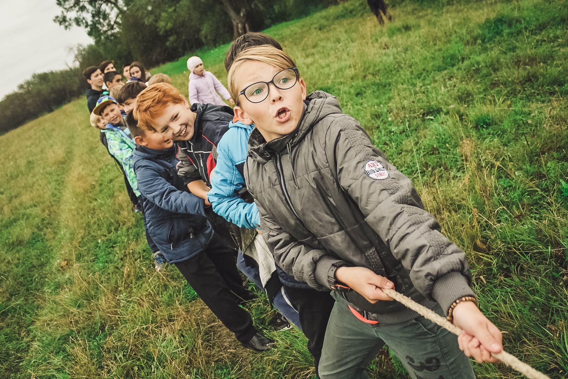 Students play tug of war in an outdoor team building activity.