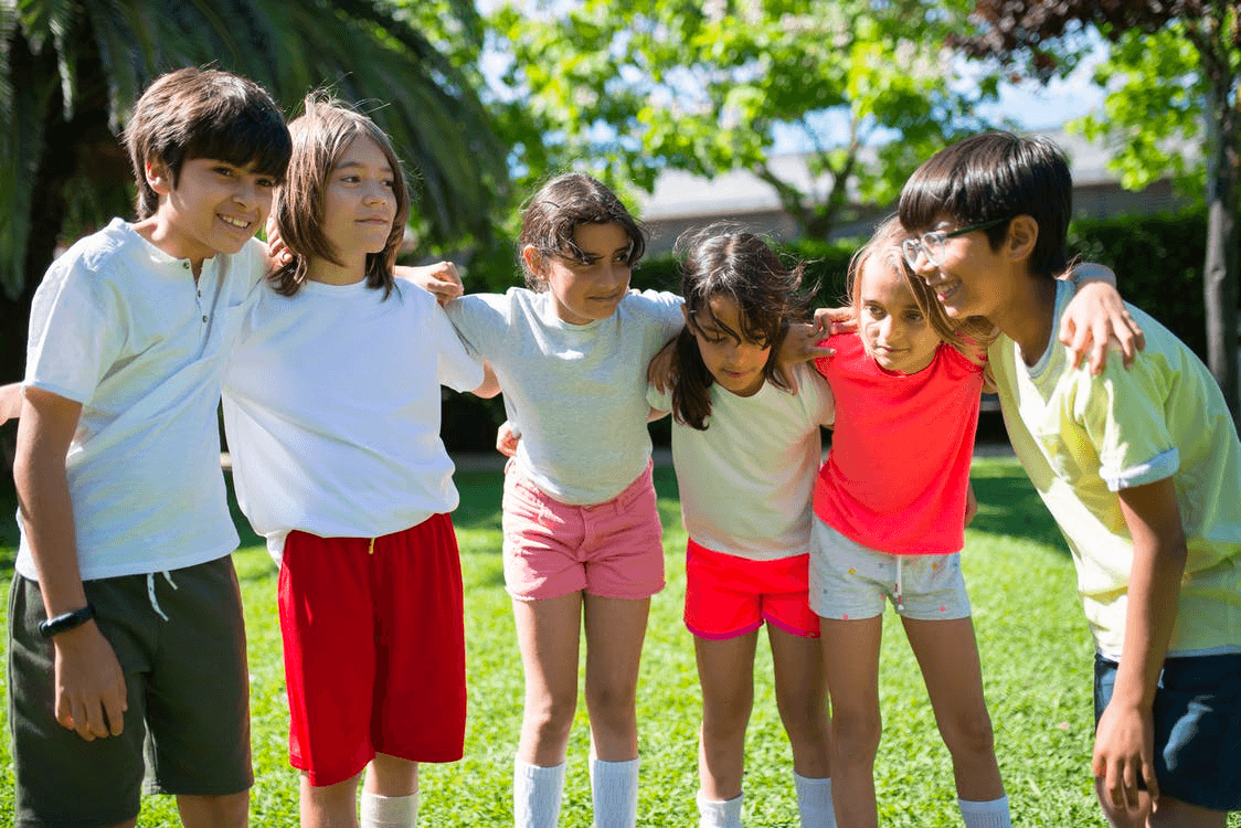 A group of students huddle outside and think of a strategy for team building activities. 