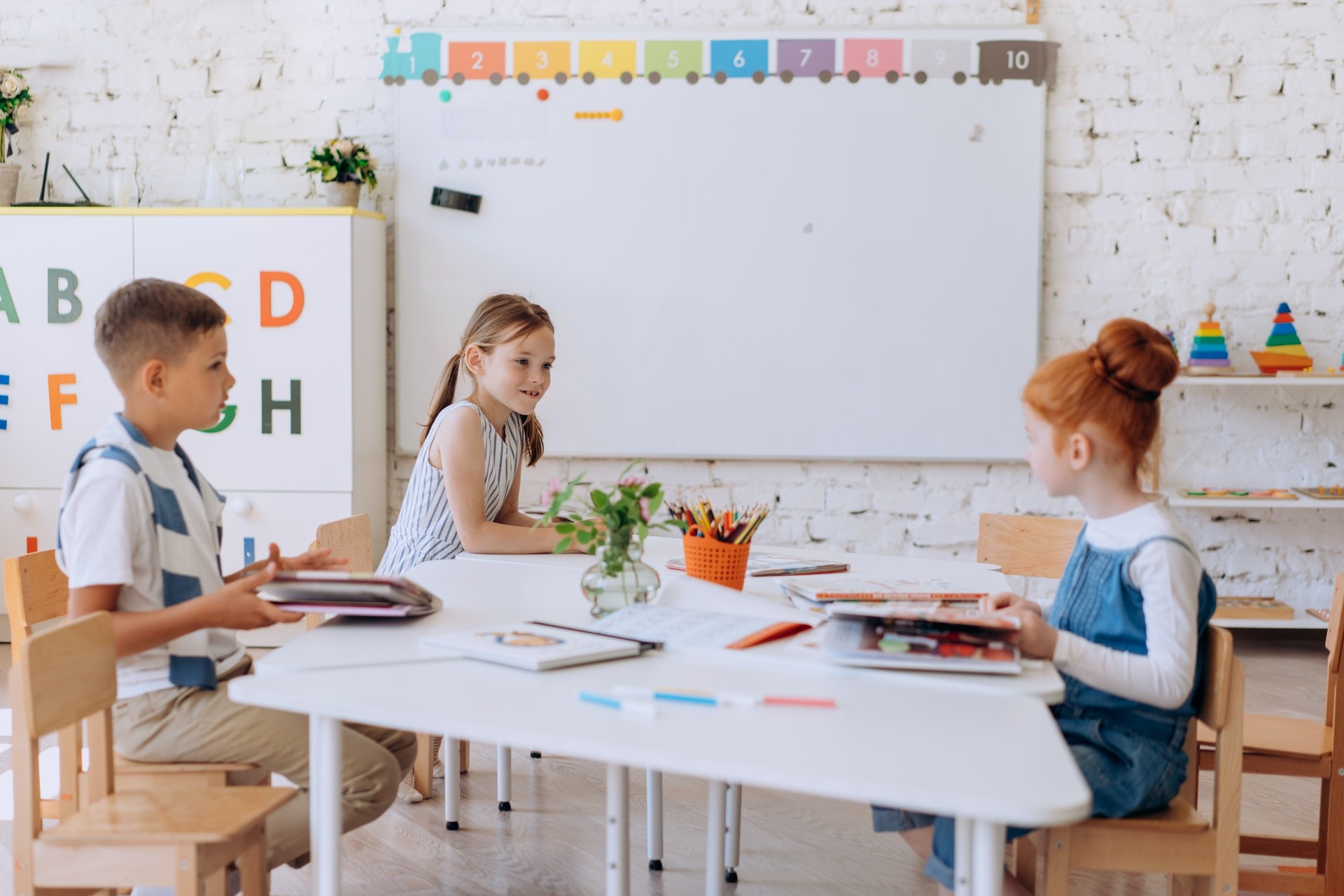 Students use word-learning strategies while sitting at a group of desks in a brightly-lit classroom.