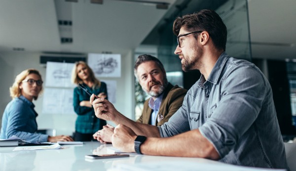 A group of educators having a conversation around a table.