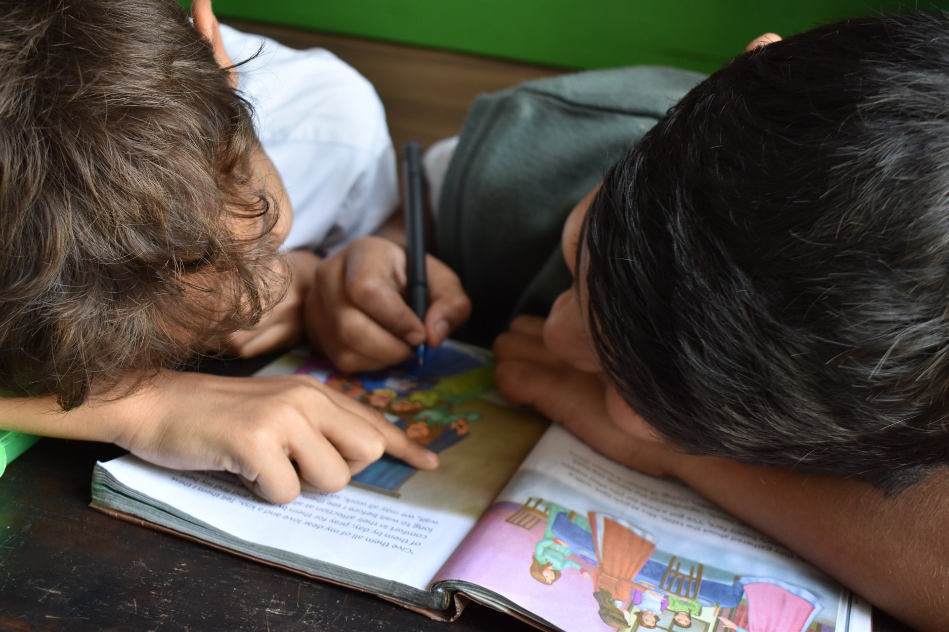 Two students work through a reading workbook during reading comprehension activities.