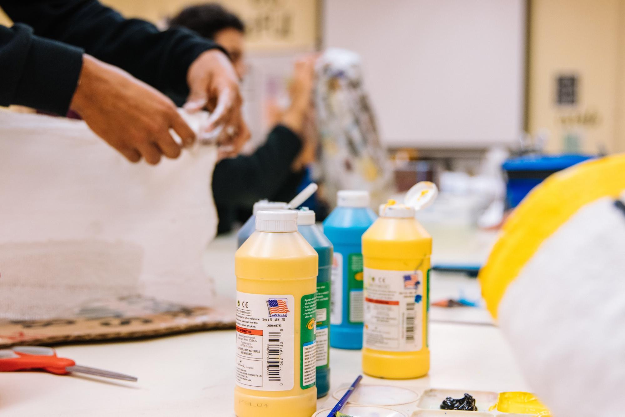 Children use paint, scissors and other craft supplies in the classroom.