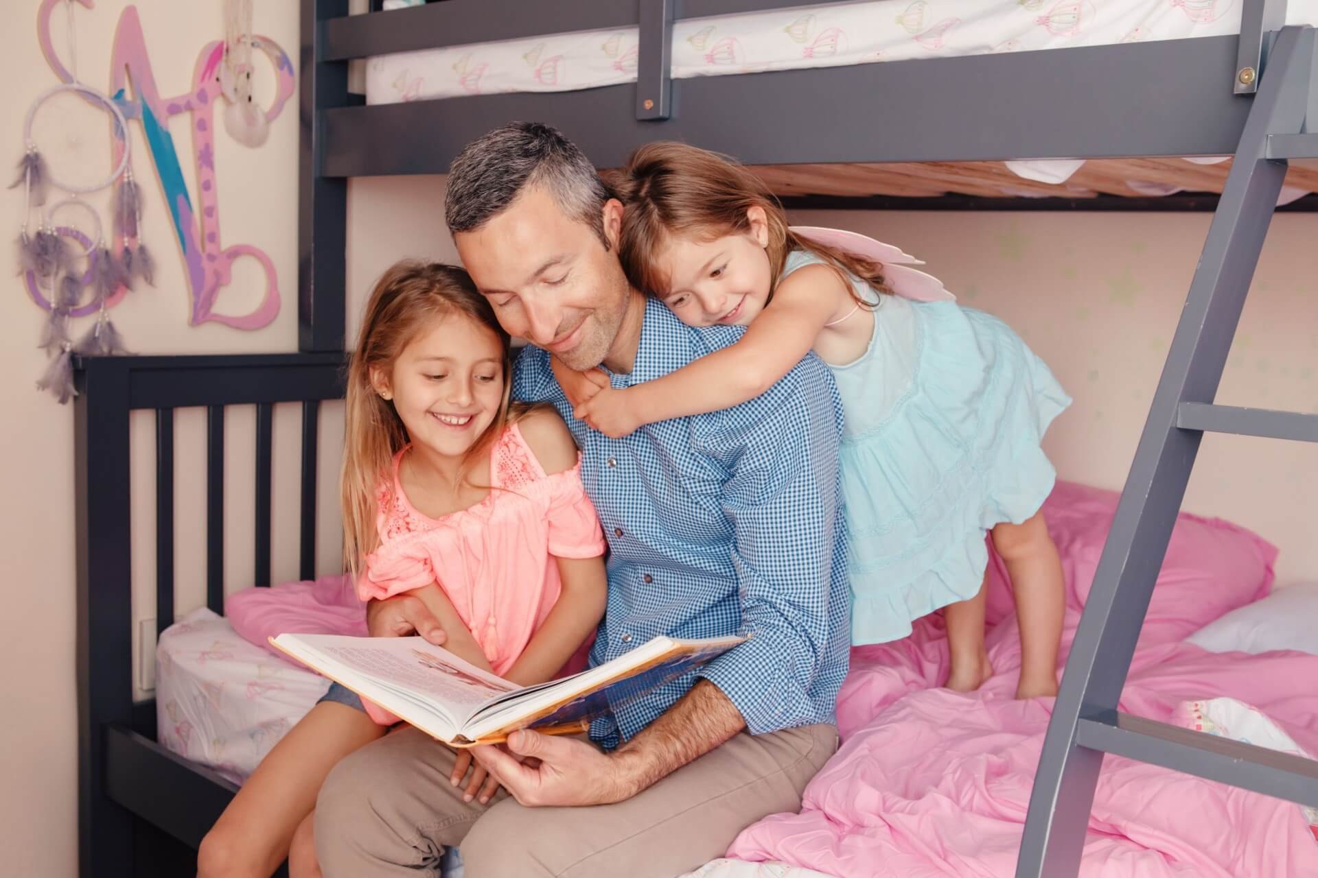 Dad reading storybook to his two daughters.
