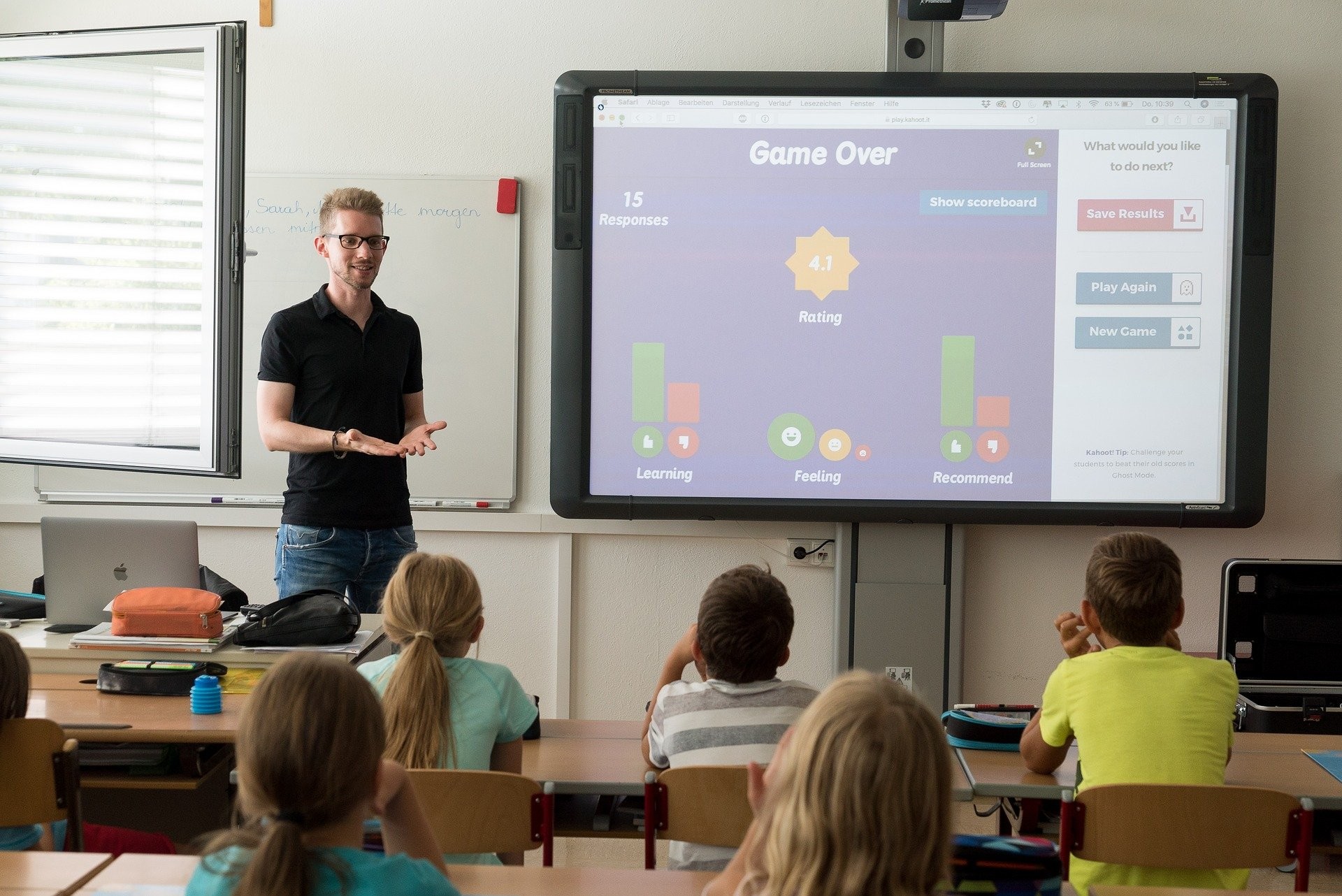 Teacher stands in front of a classroom, using gamification to align Bloom's taxonomy with his classroom teaching.