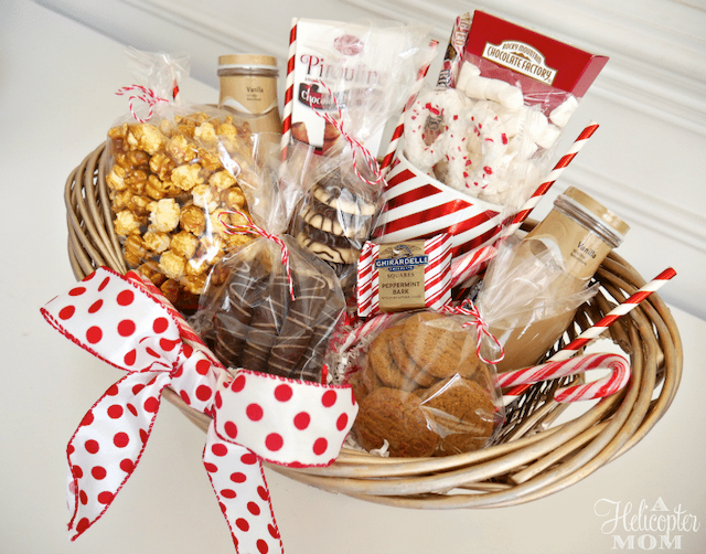 DIY wicker gift basket with a white and red polka-dotted ribbon and filled with holiday treats.