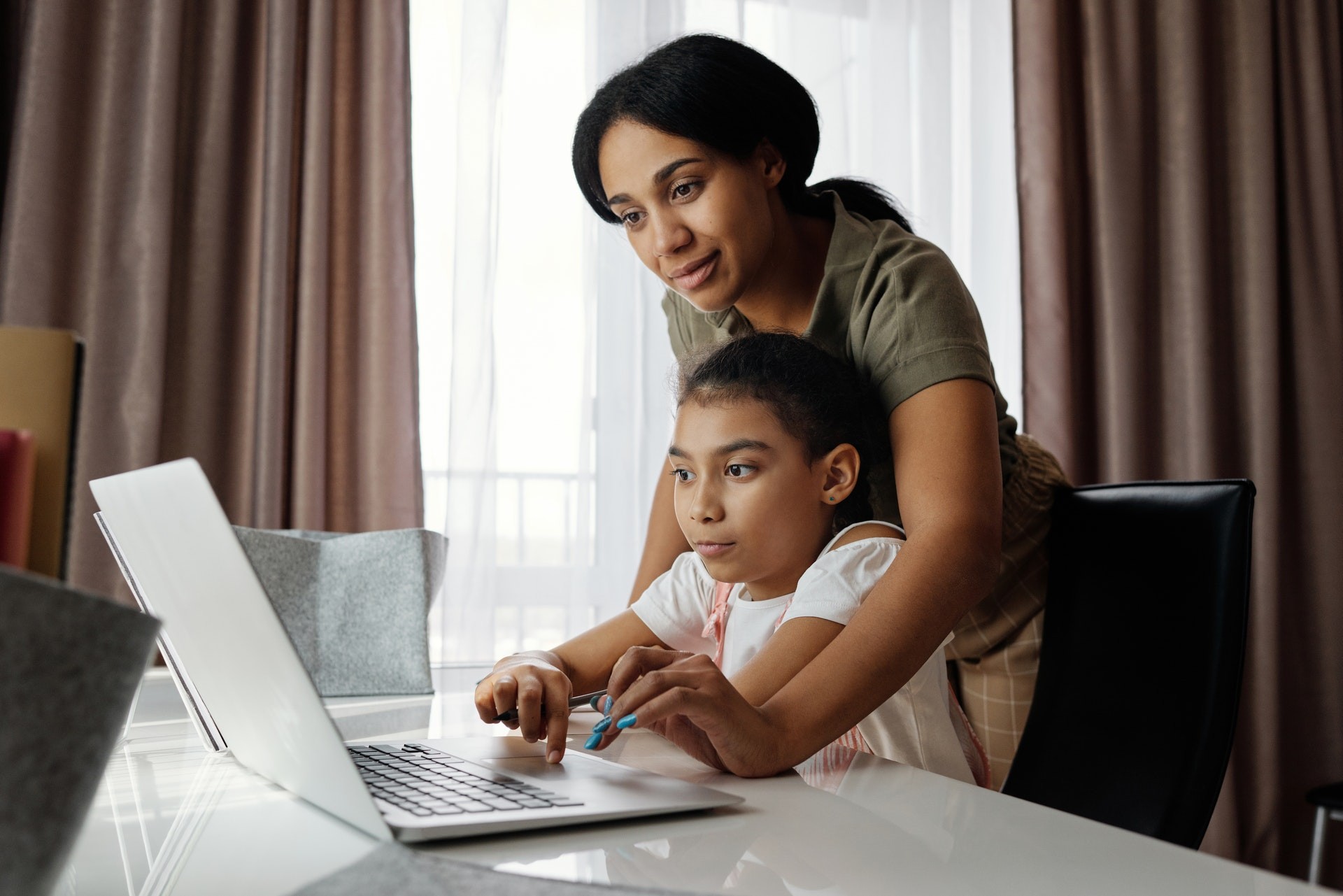 Mother and daughter work together on a computer