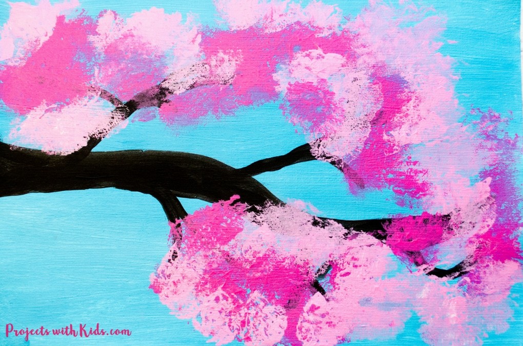 Blue canvas with pink cherry blossom tree painted on it