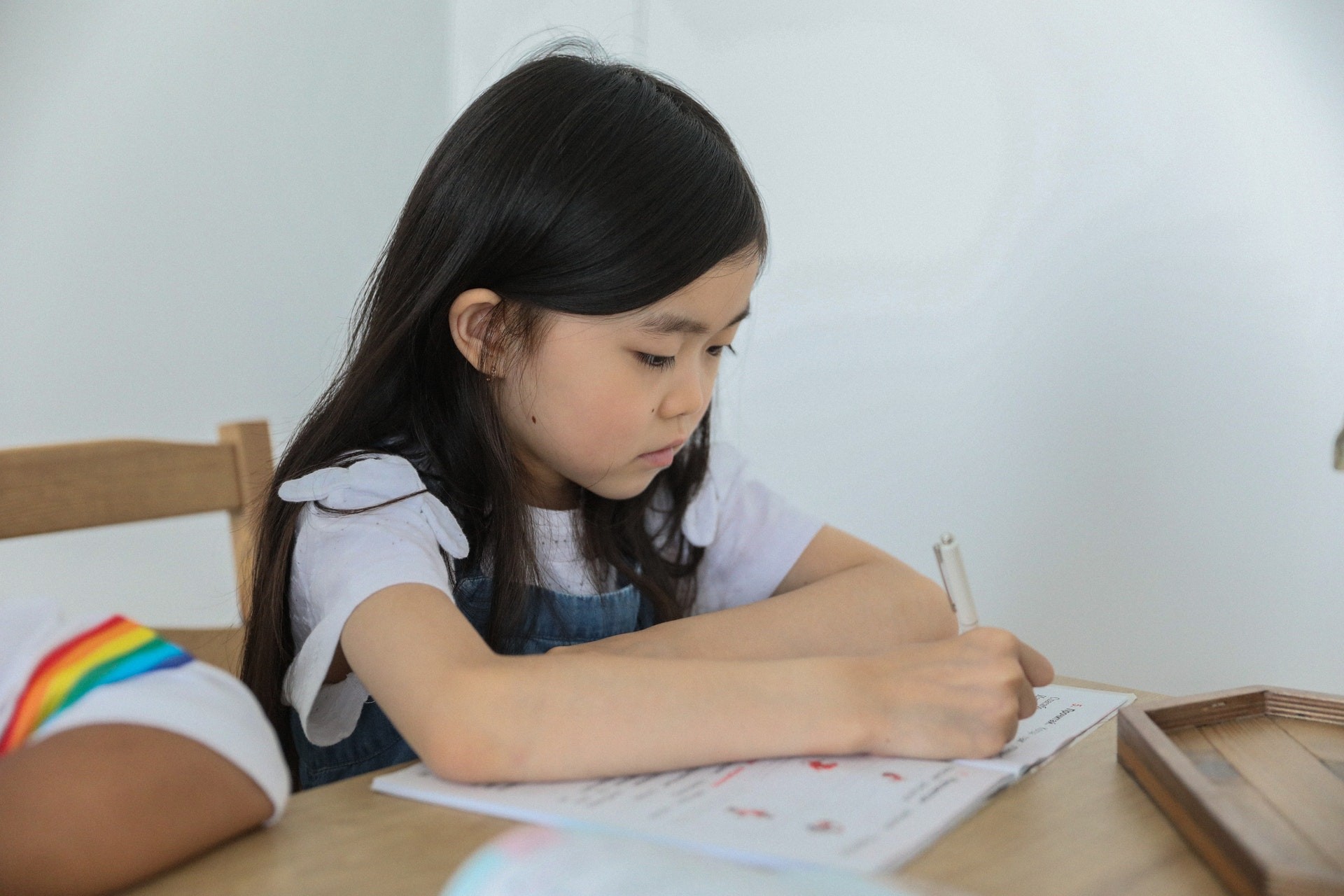 A young student works on her math homework in the classroom