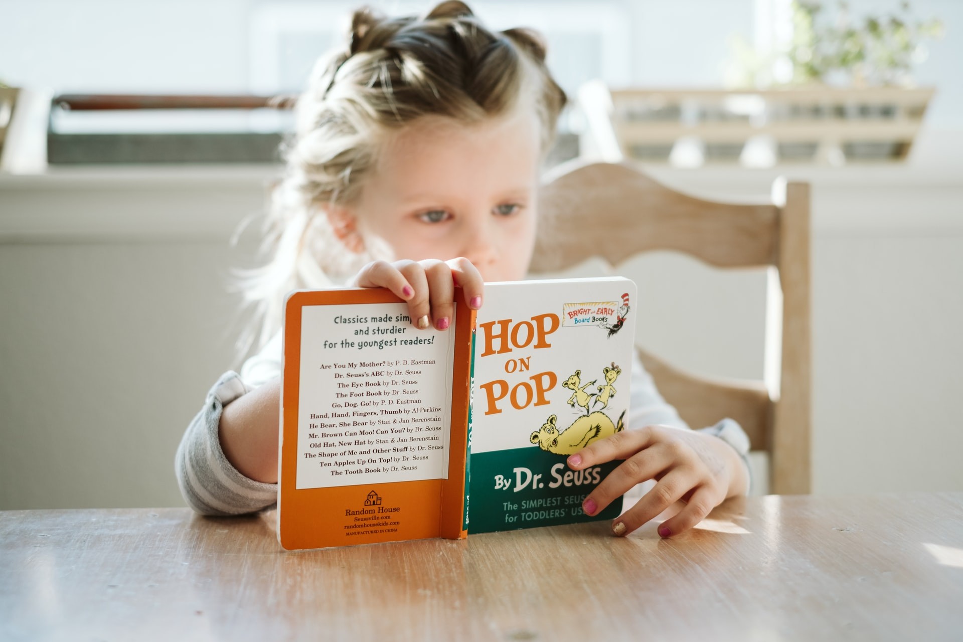 Young girl reads "Hop on Pop" during reading strategies in the classroom.