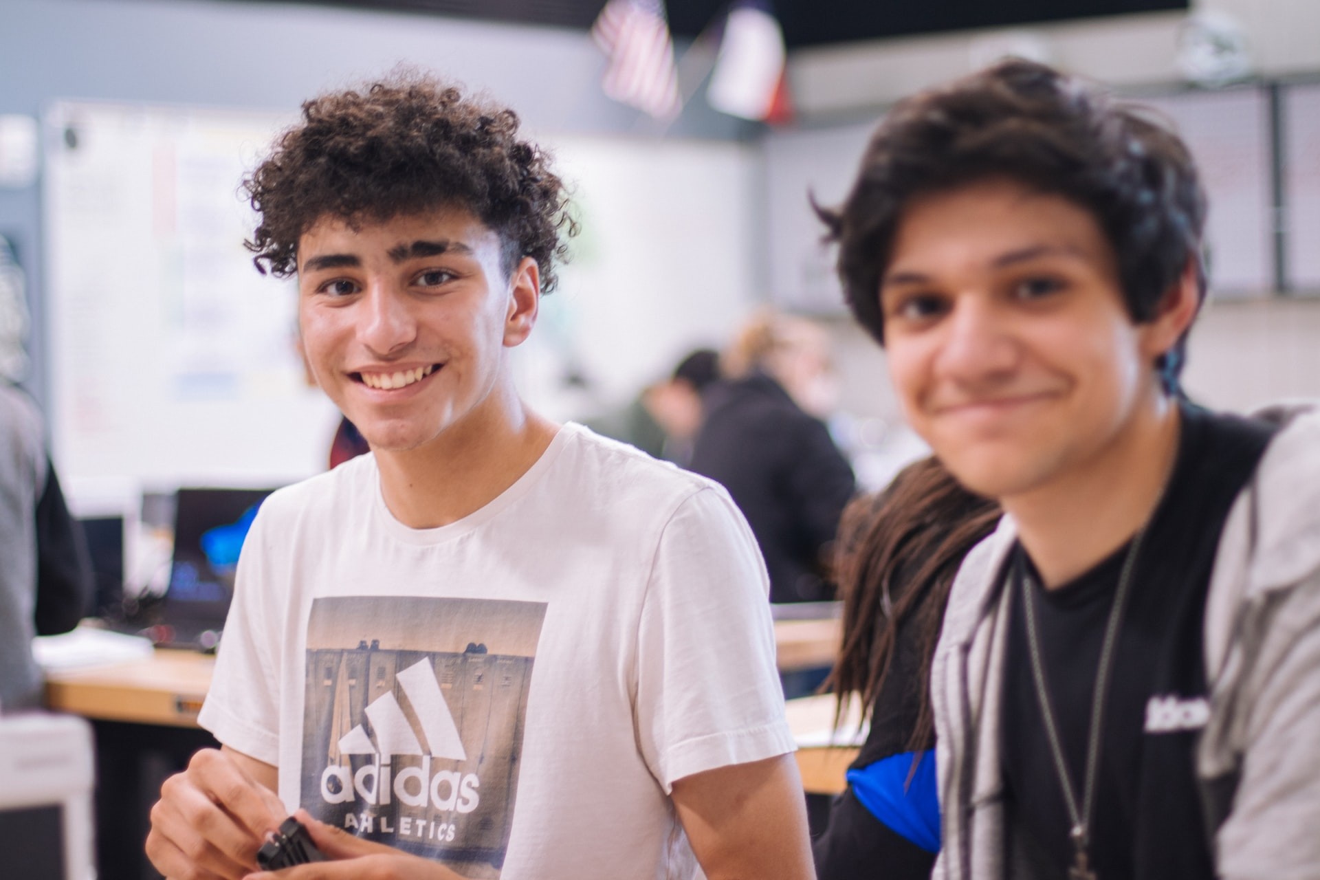 Two male students smile at the camera during project-based learning activities. 