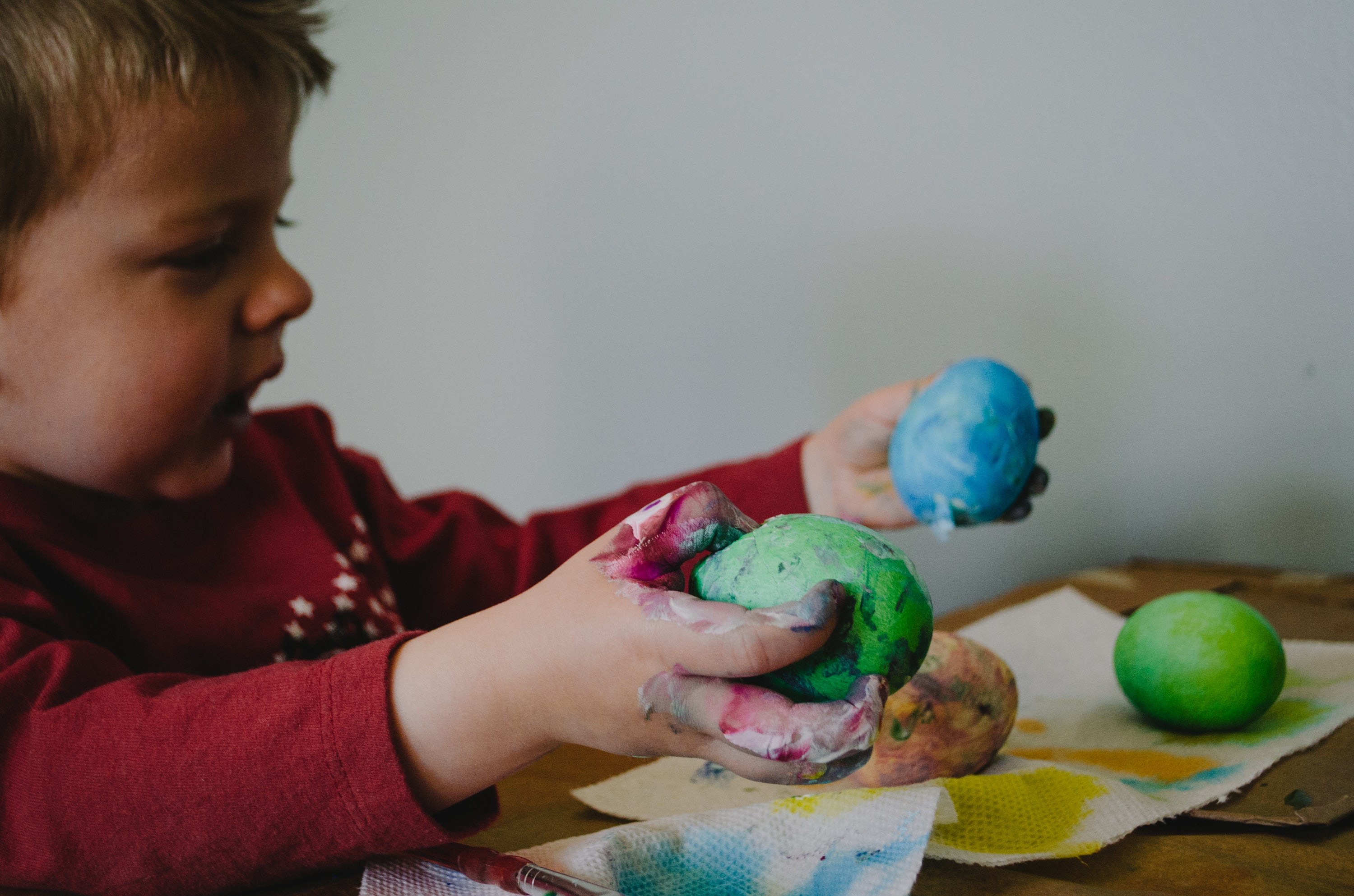 A child plays with colorful salt dough while doing earth day activities for kids.