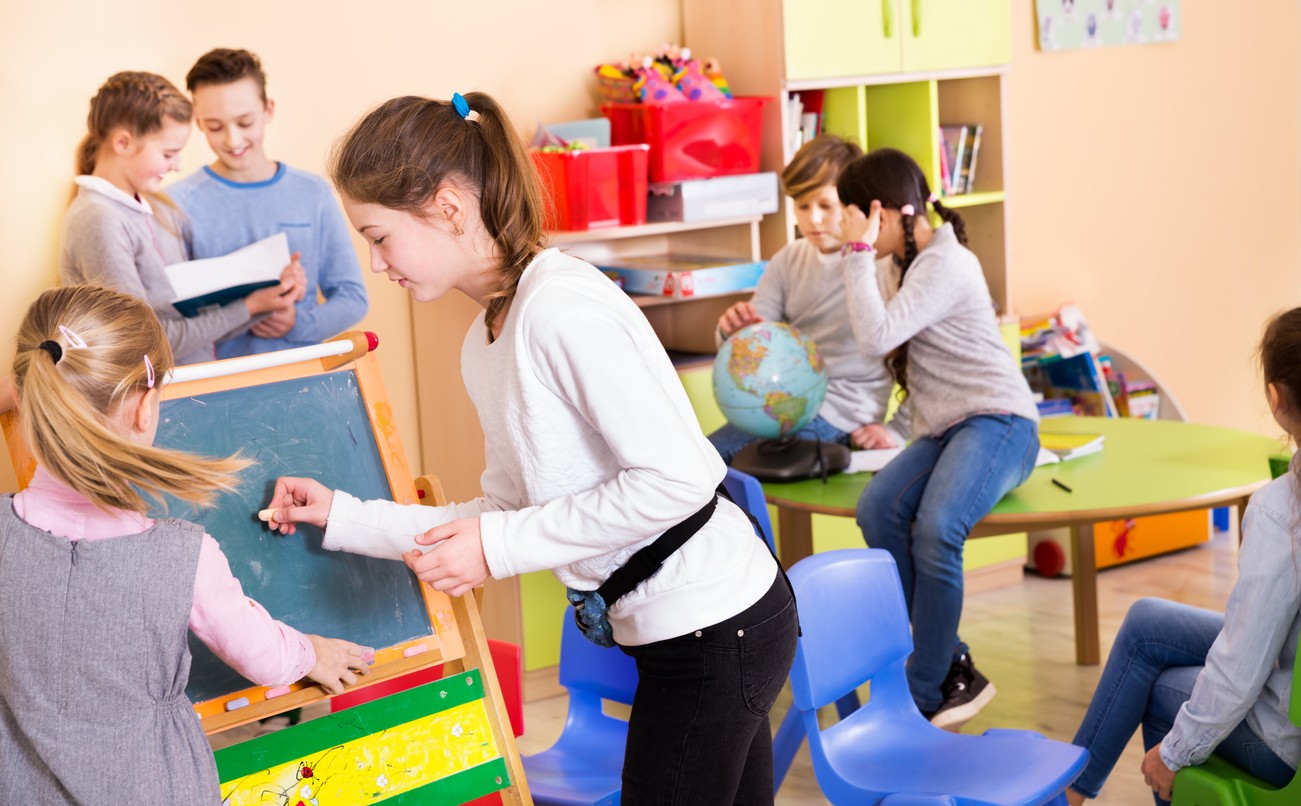 Elementary school children scattered around the classroom during student-centered learning.