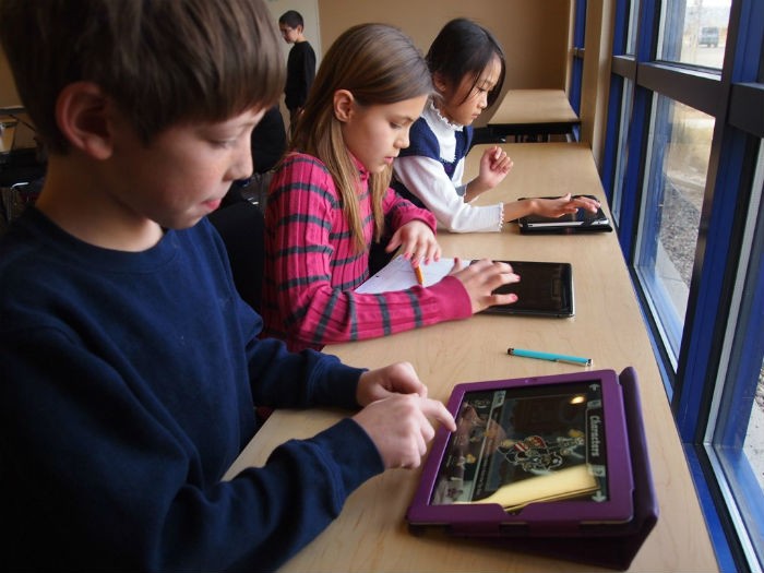 Students playing learning games on tablet computers.