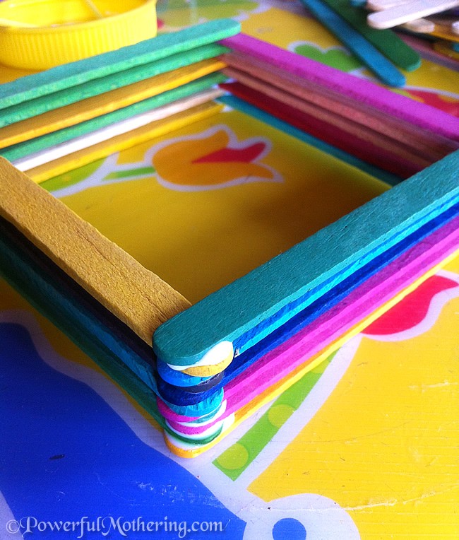 Small treasure box made from layers of colorful popsicle sticks.