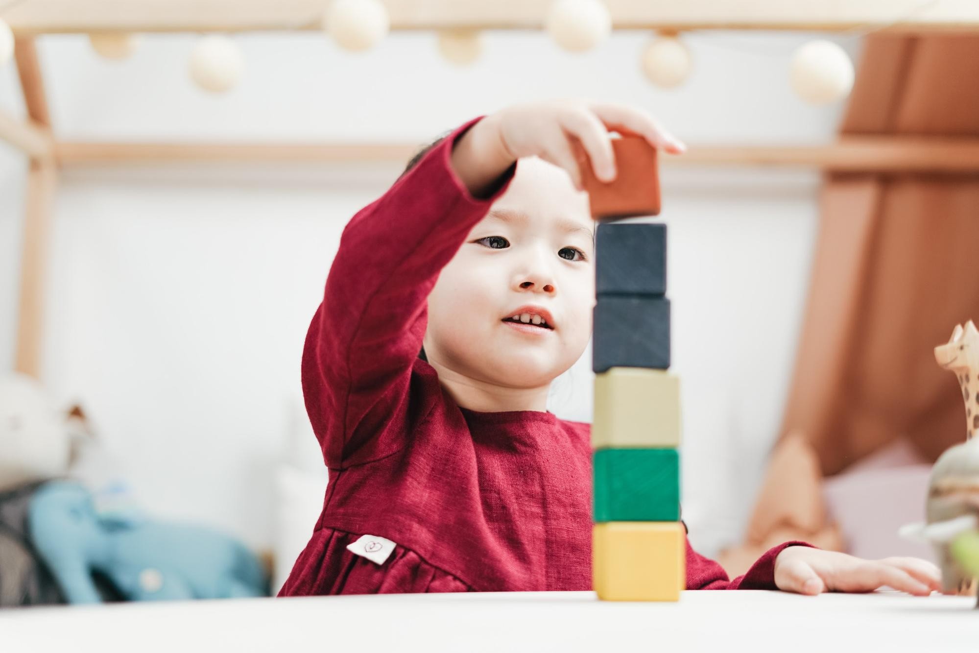 Young child plays with building blocks in the classroom.