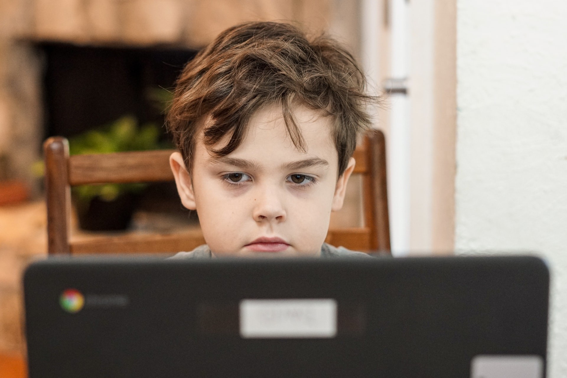 Young boy works on a computer during a virtual learning session.