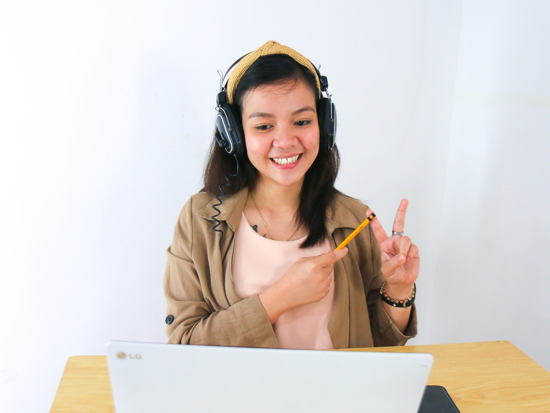 Young woman with headphones on teaches using a virtual classroom.