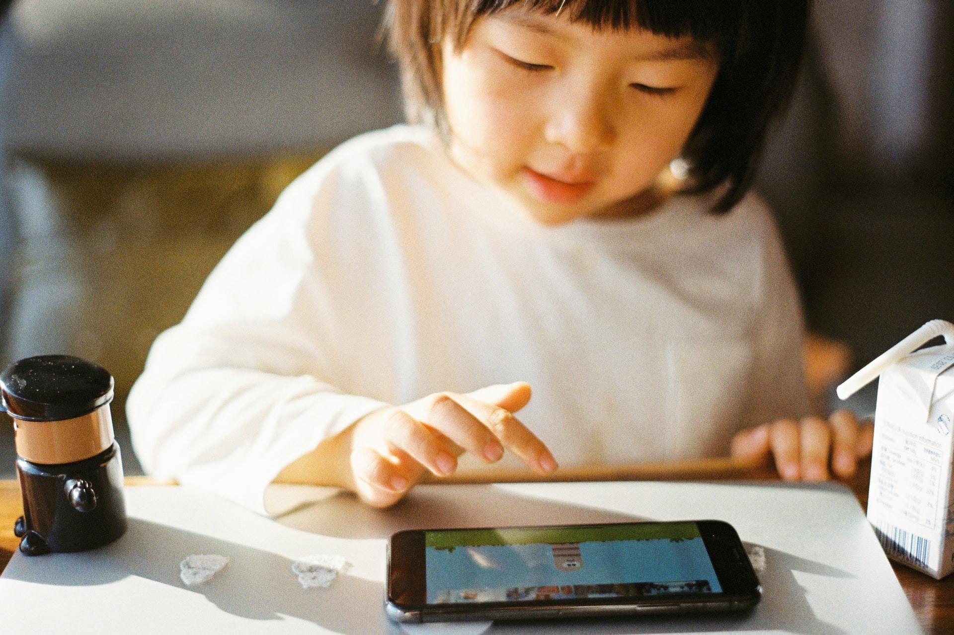Young girl plays on a tablet while practicing ELL skills.