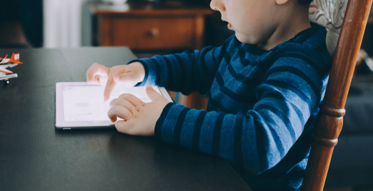 Child using a reading app at the kitchen table