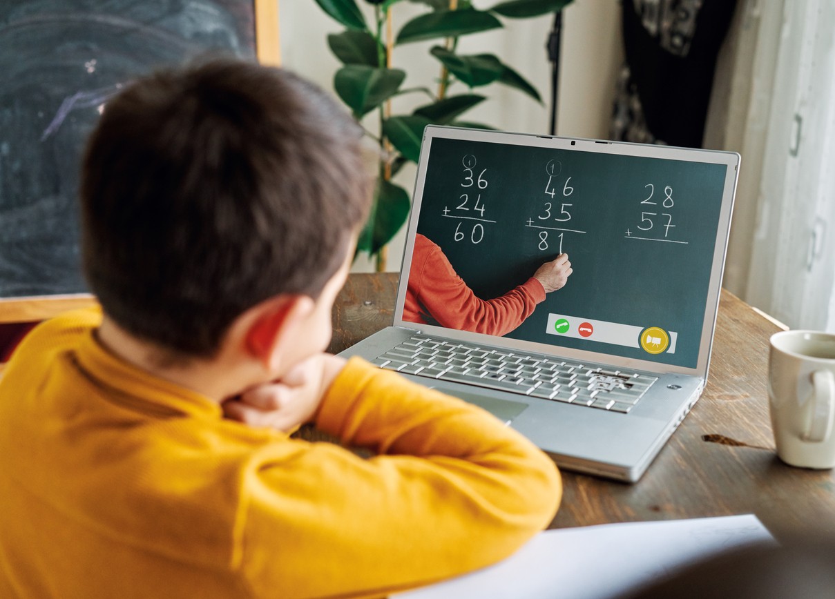 A young boy watching a math lesson on his laptop.