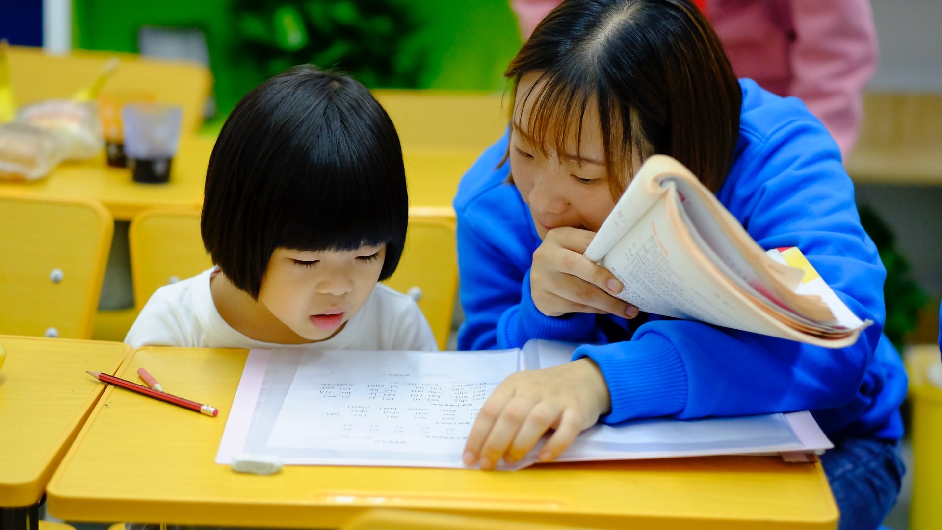 A teacher and a student work together in the classroom on phonemic and phonological awareness activities.