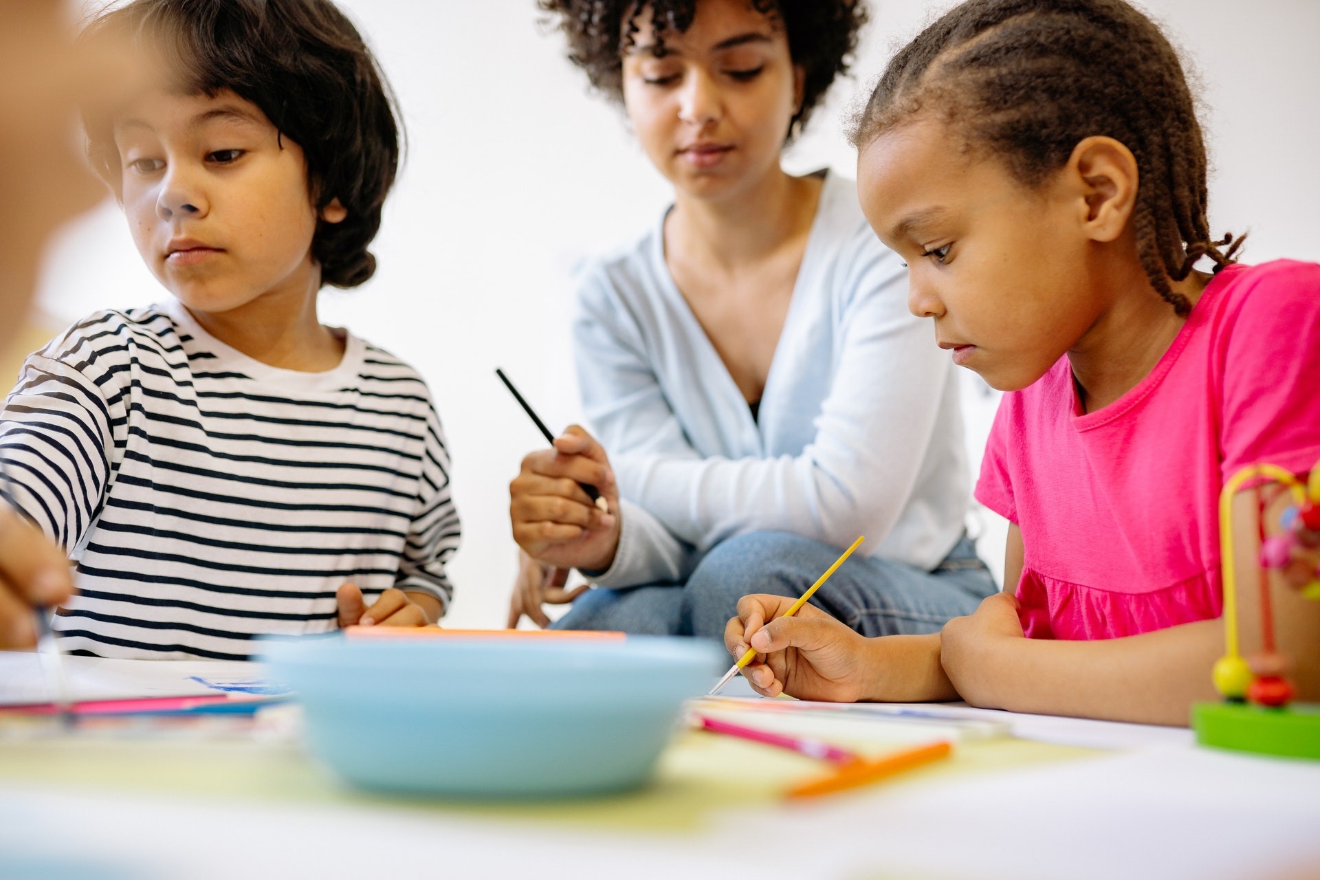 A teacher and two students complete phonemic awareness activities in the classroom.
