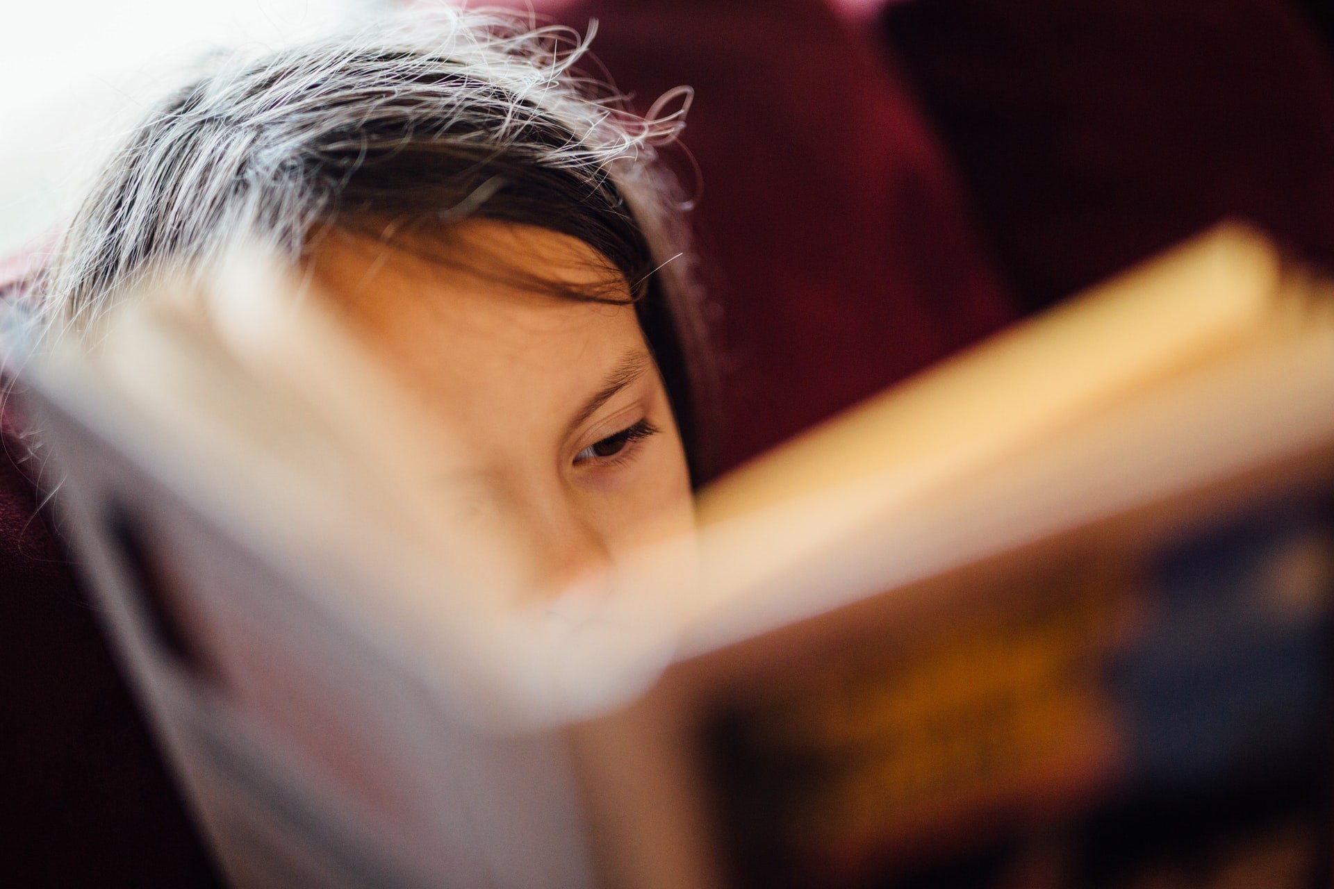 Close-up picture of a child reading a book. 
