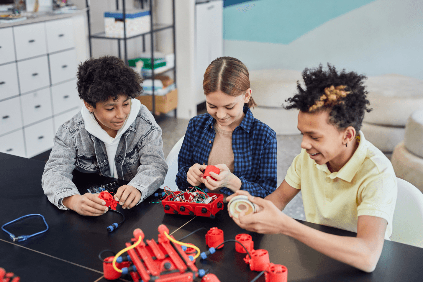 Three students doing a robotics project together in their after-school STEM program.