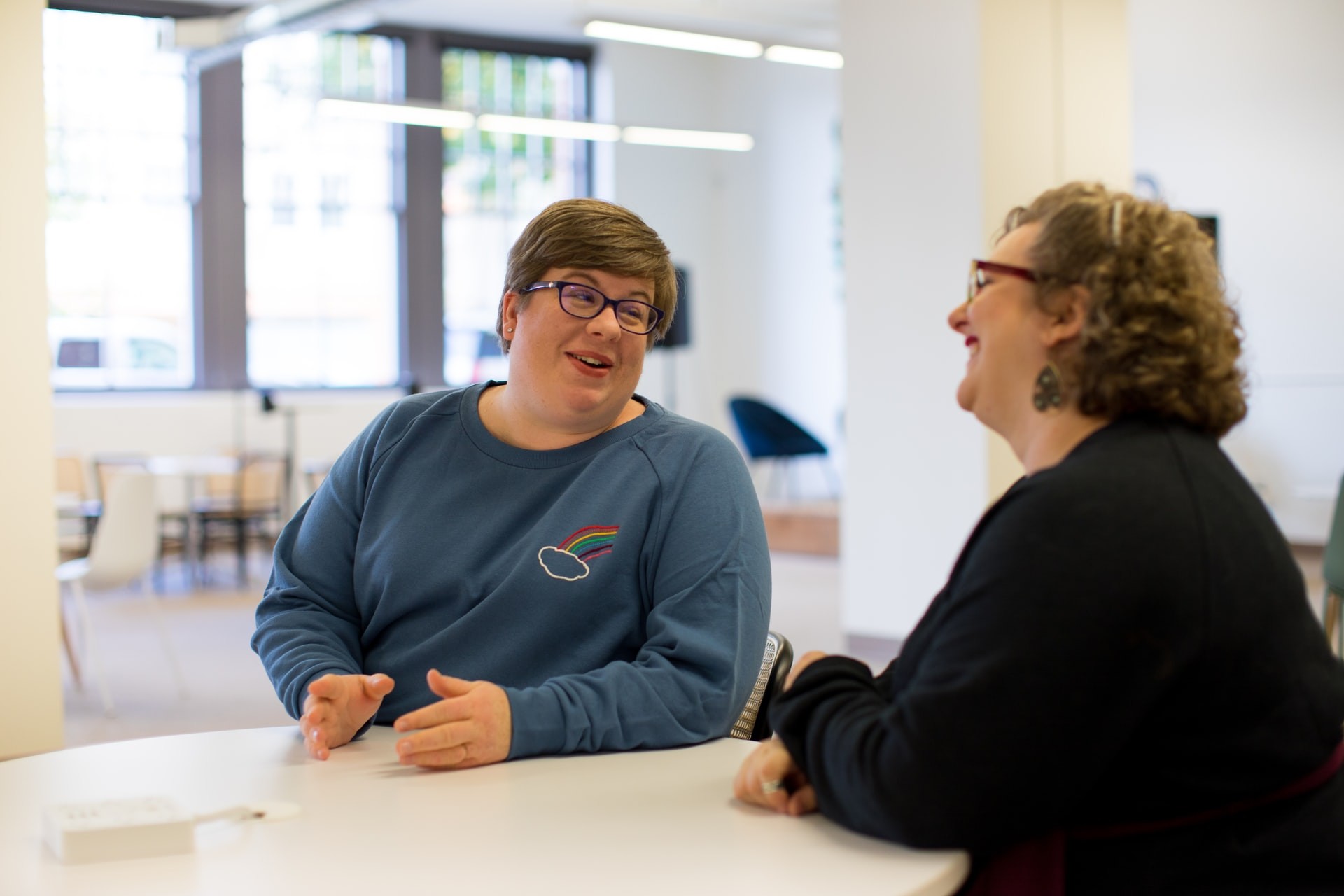 A teacher and a parent having a conversation at school.