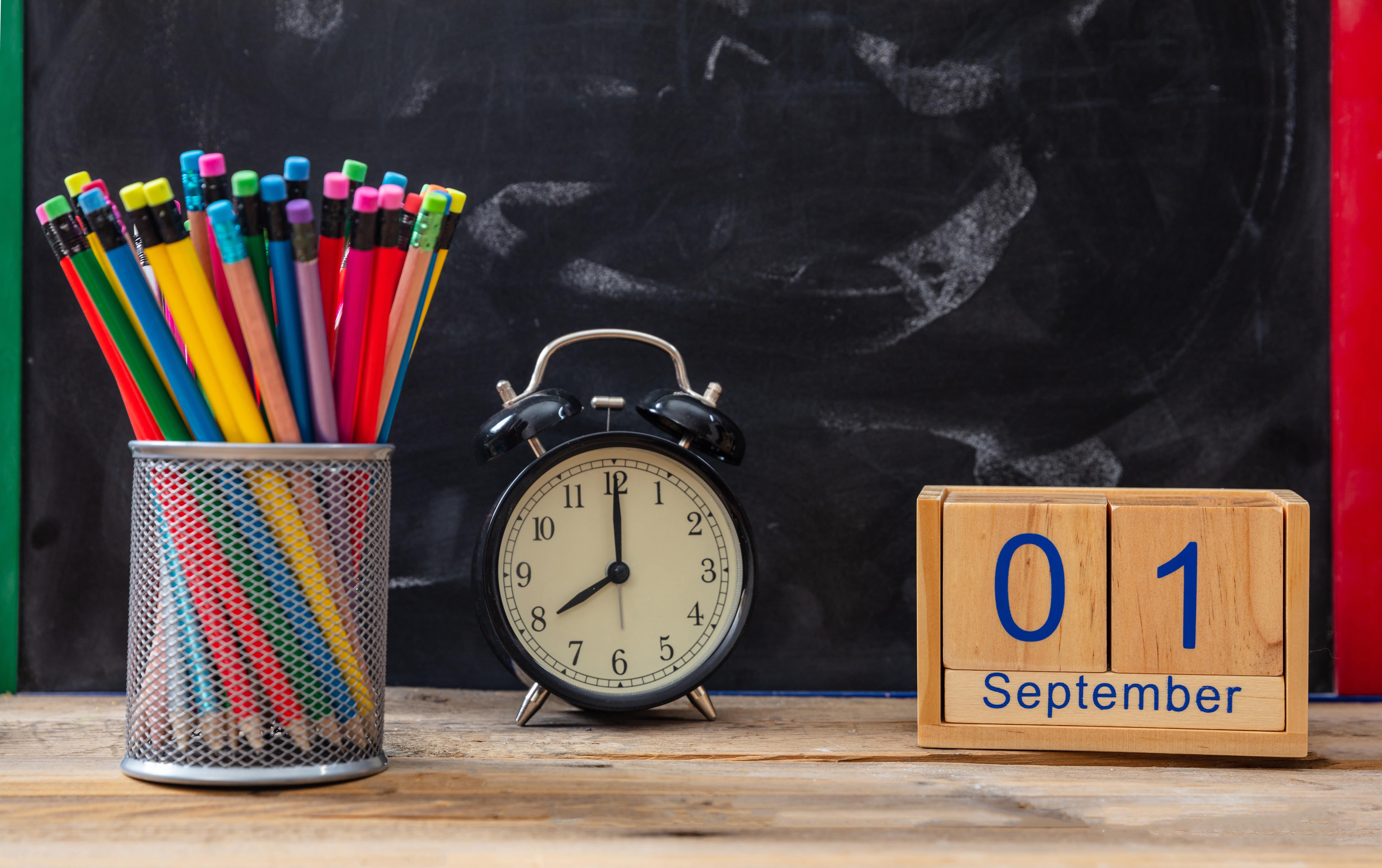 organized desk with pencils and clock