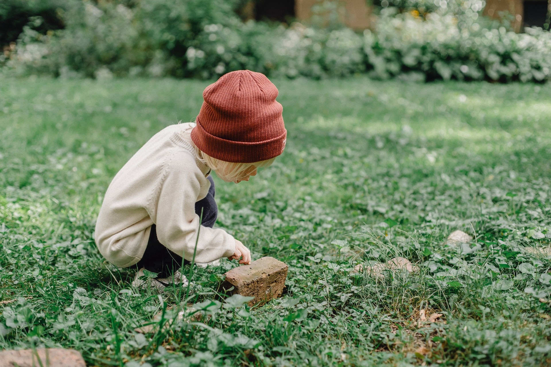 A young boy investigates a rock during some earth day activities for kids.