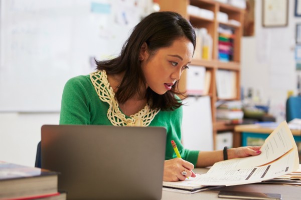 Teacher sitting at her desk and grading work