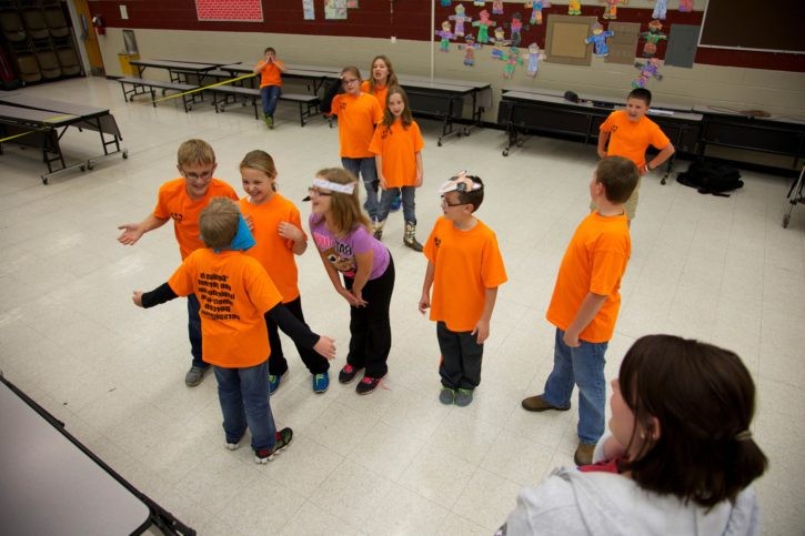 A group of students play a game in their classroom.