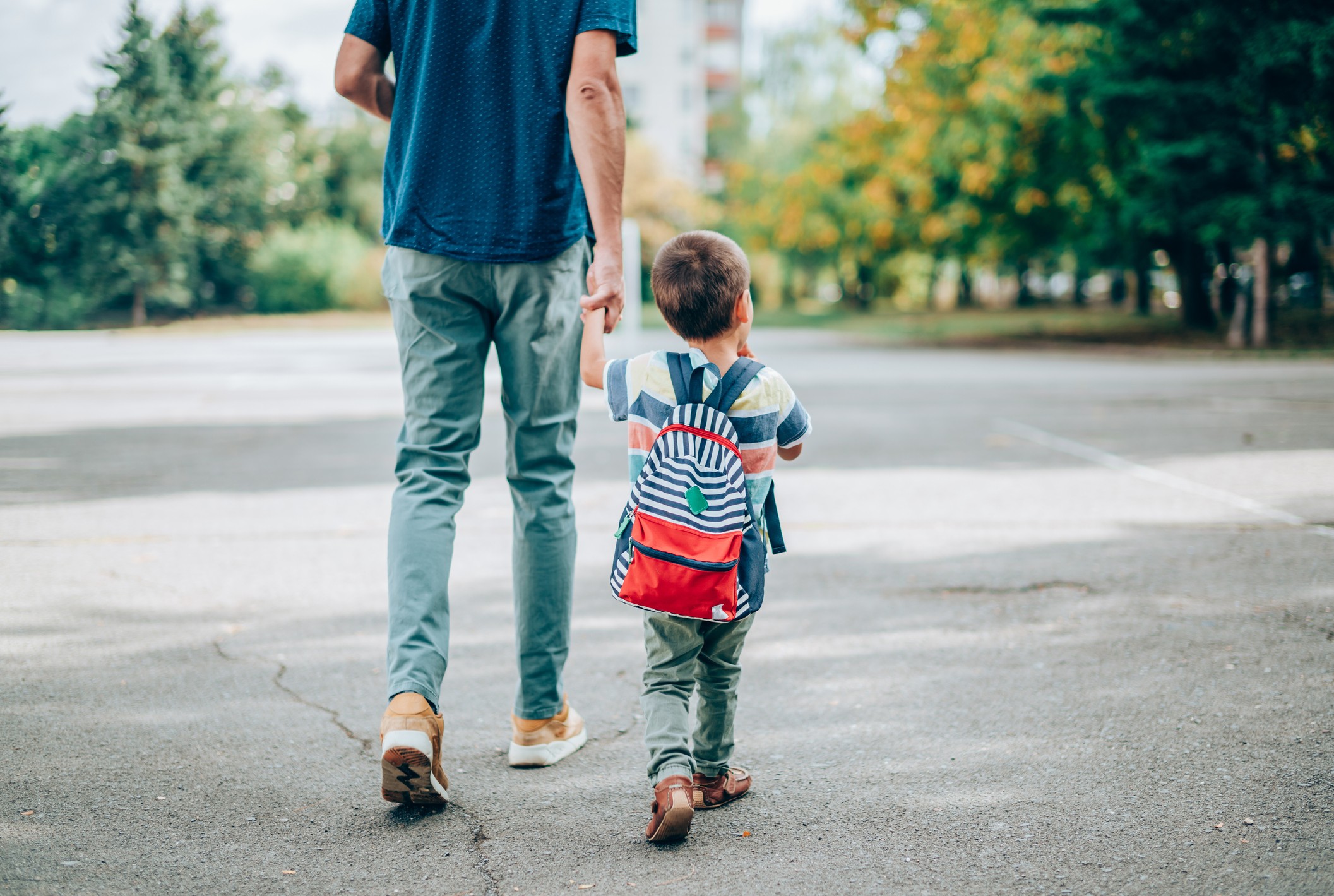 A Dad walks with his child from school.