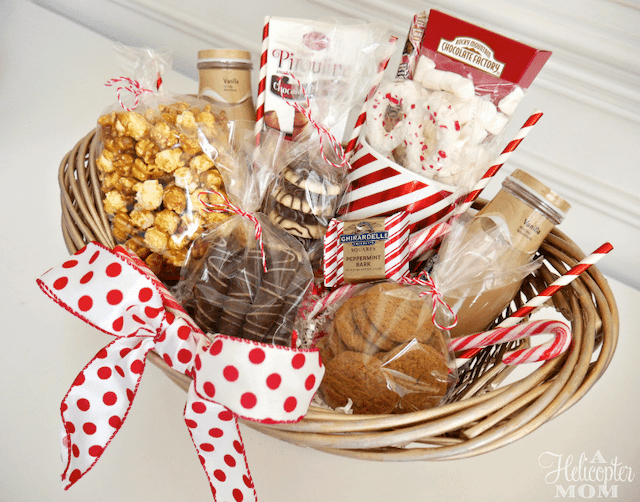 DIY wicker gift basket with a white and red polka-dotted ribbon and filled with holiday treats.