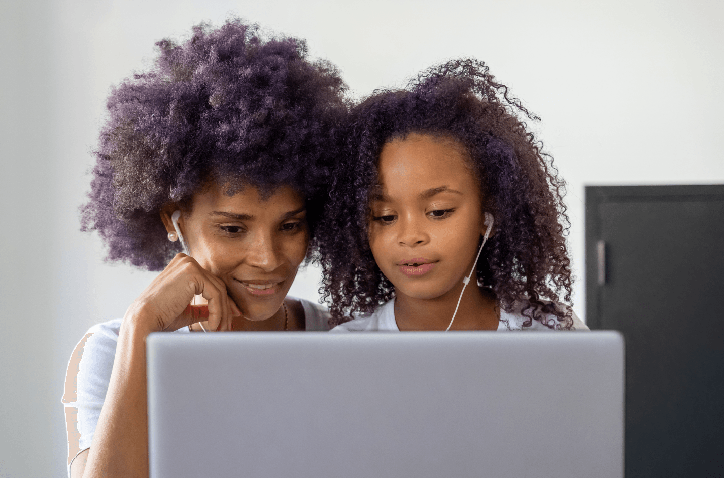 Child and her mother on a computer together after school