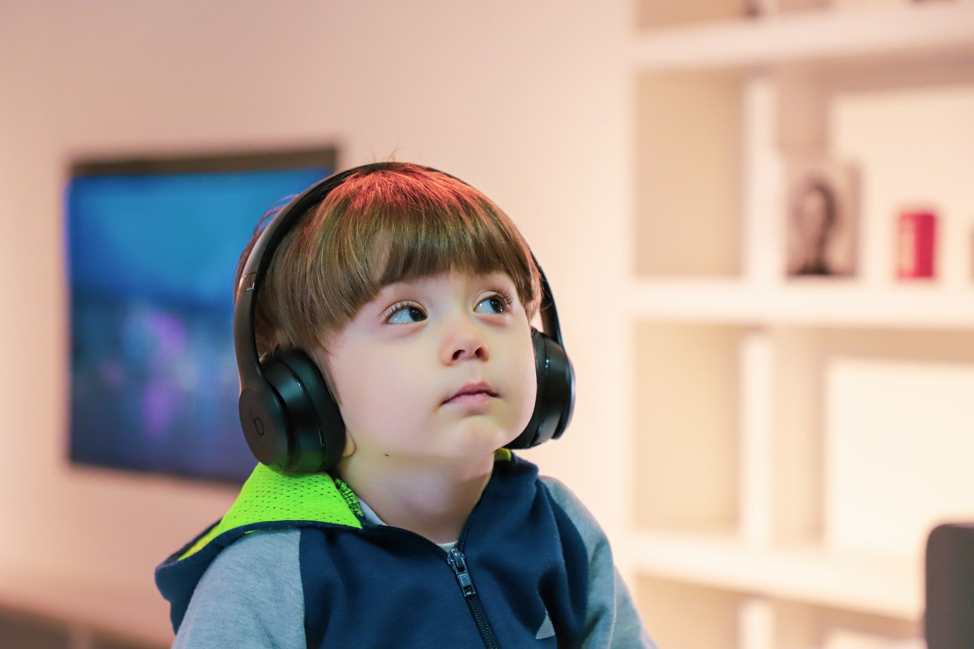 Young boy listens to over ear headphones during alternate ELL activities.