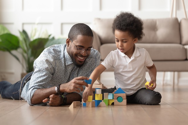 Father and son building a house out of blocks together