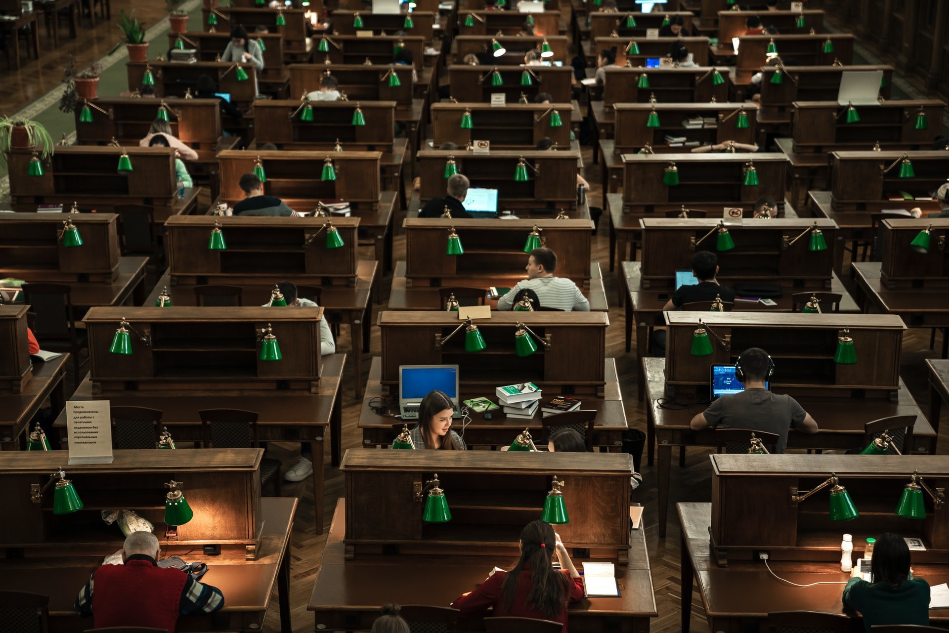 Overhead shot of students studying in a large college library.