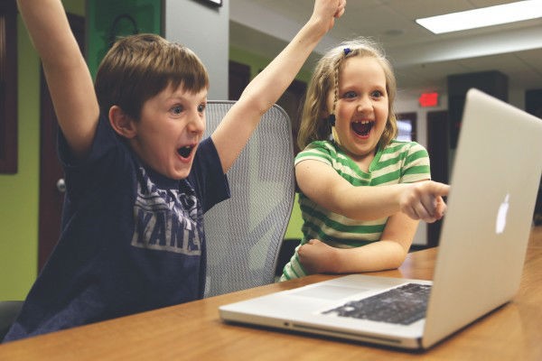 Boy and girl in front of laptop excited to play the best browser games