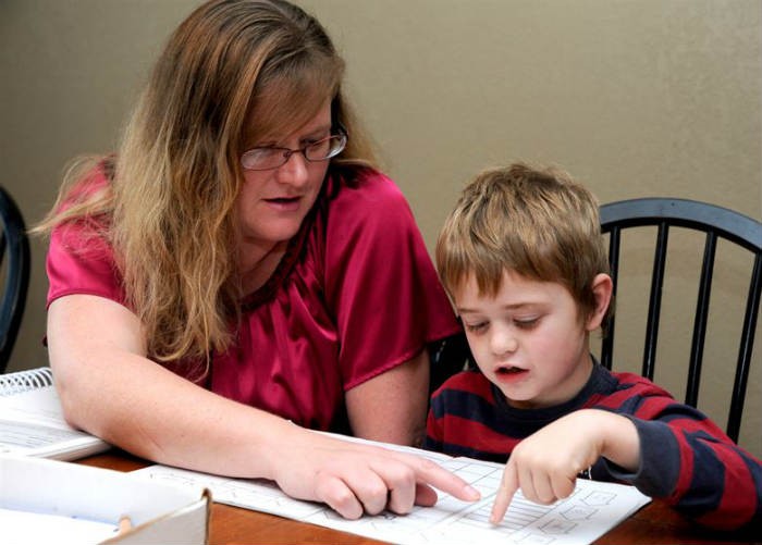 Parent supporting her child as they work through math homework.