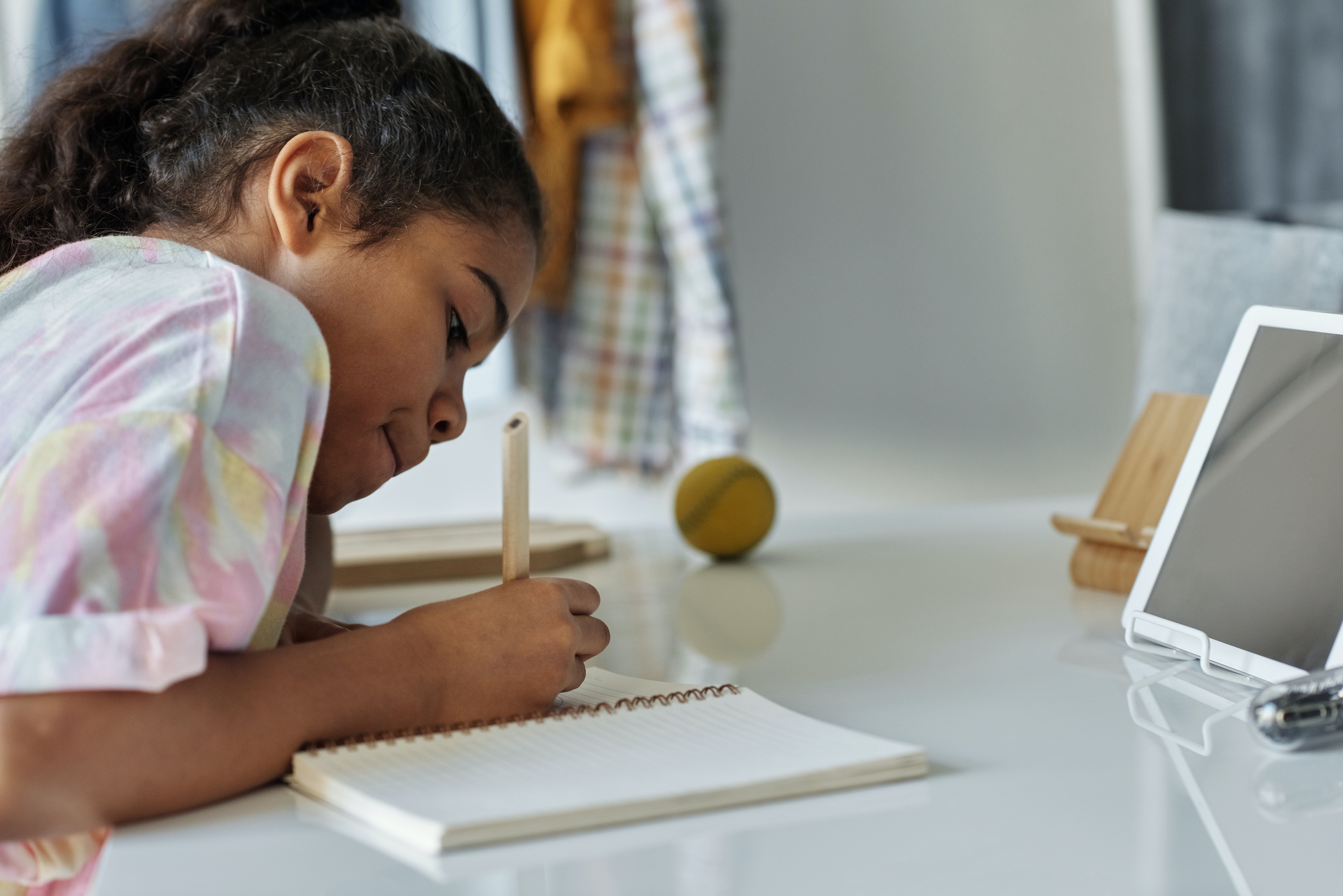 Young girl doing schoolwork in front of computer.